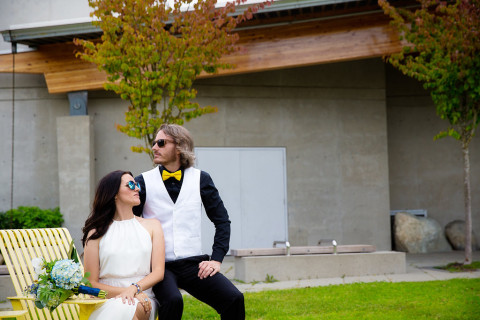 Newlyweds wearing sunglasses and looking in different directions for a funny photo in front of Trout Lake Community Centre after their Trout Lake Park elopement