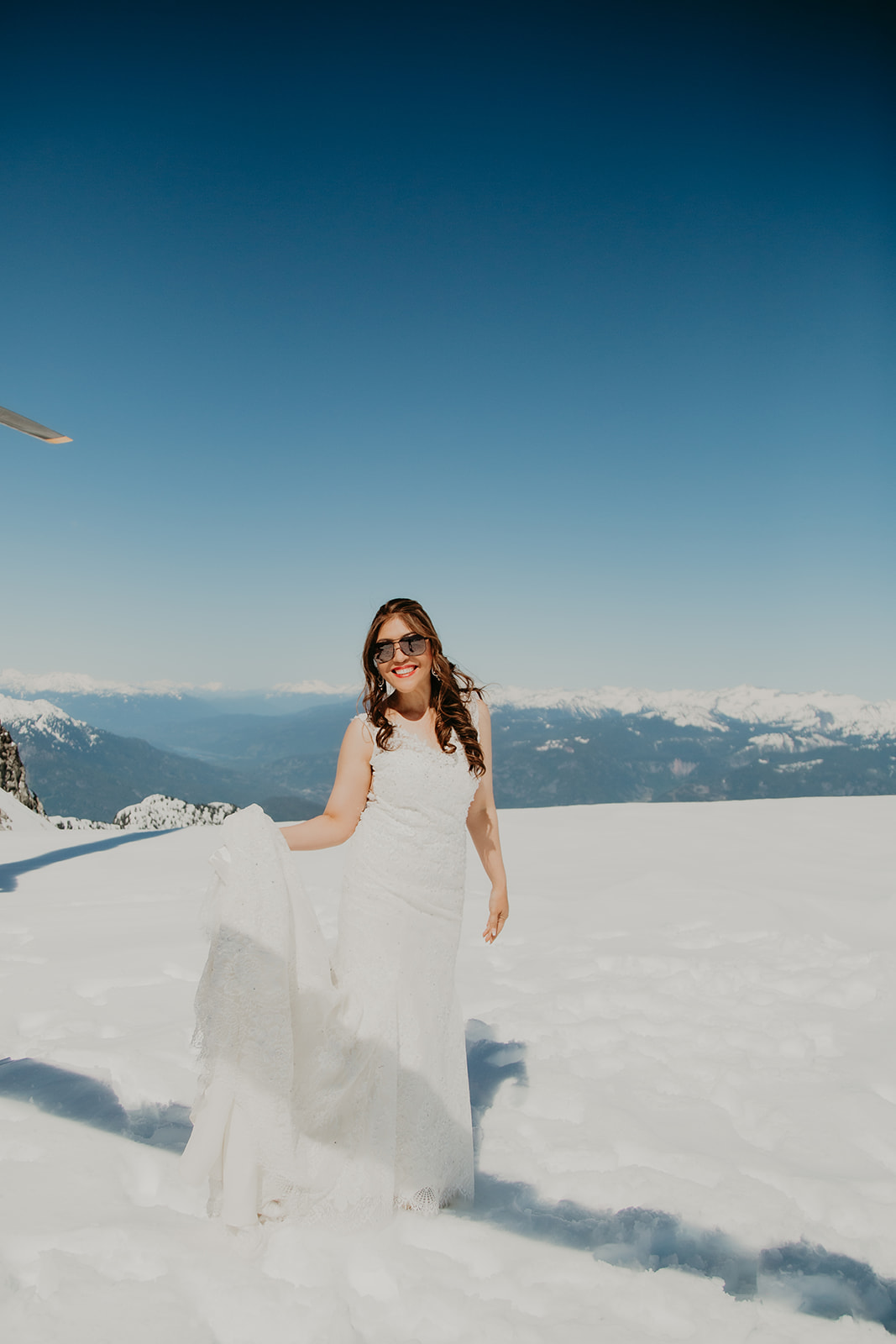 Squamish elopement with Blackcomb Helicopter, bride in white on mountaintop