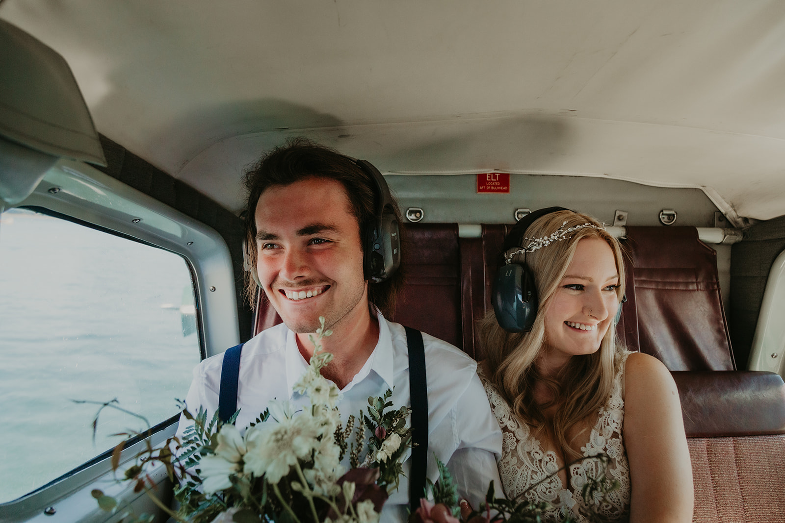 bride and groom inside plane for seaplane elopement package with young hip and married