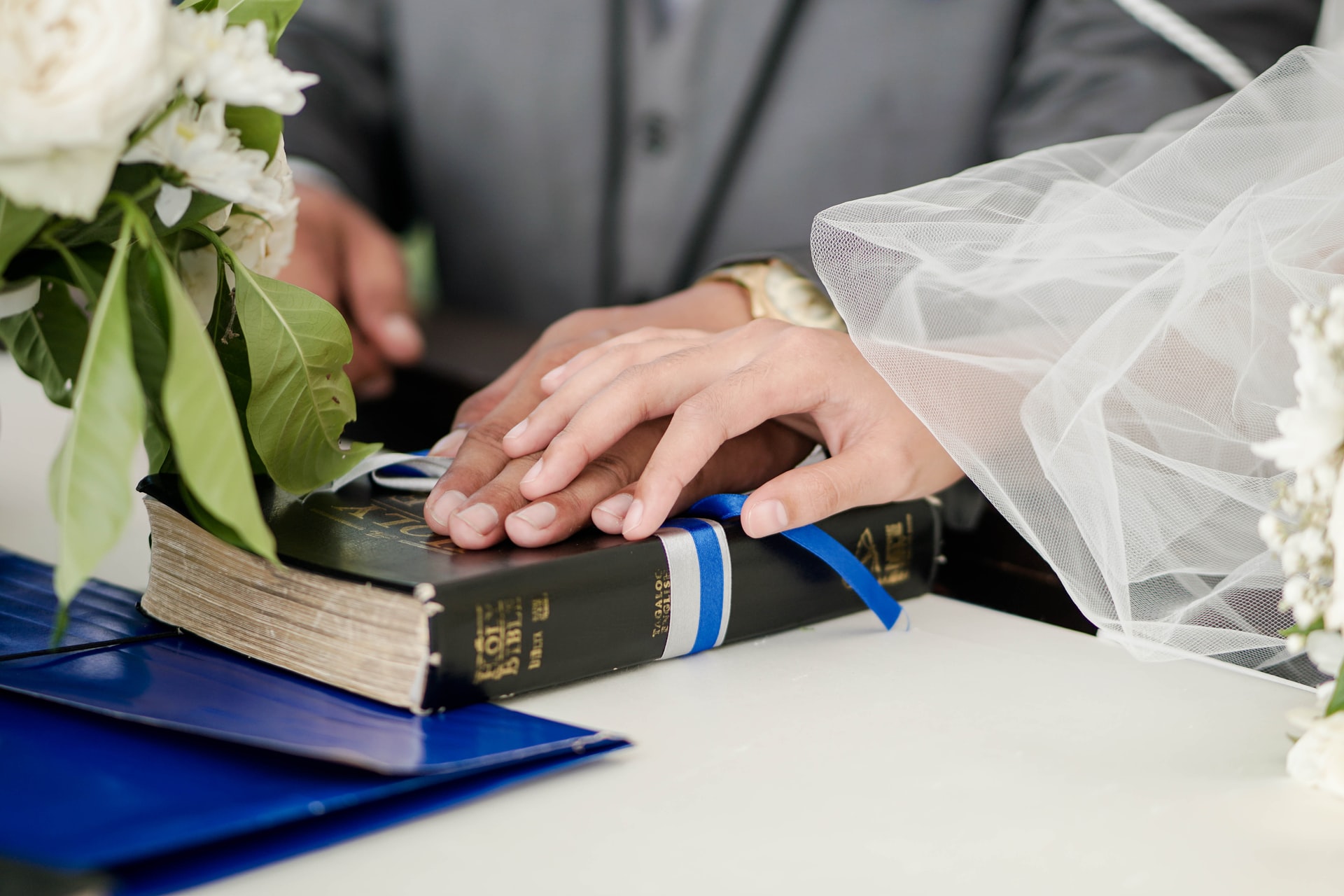 bride and groom with hands on the bible at their religious wedding ceremony