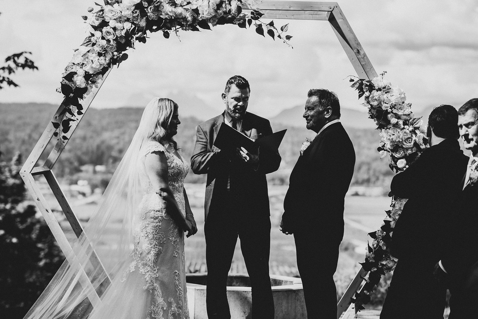 black and white photo of couple at their wedding ceremony with young hip and married wedding officiants