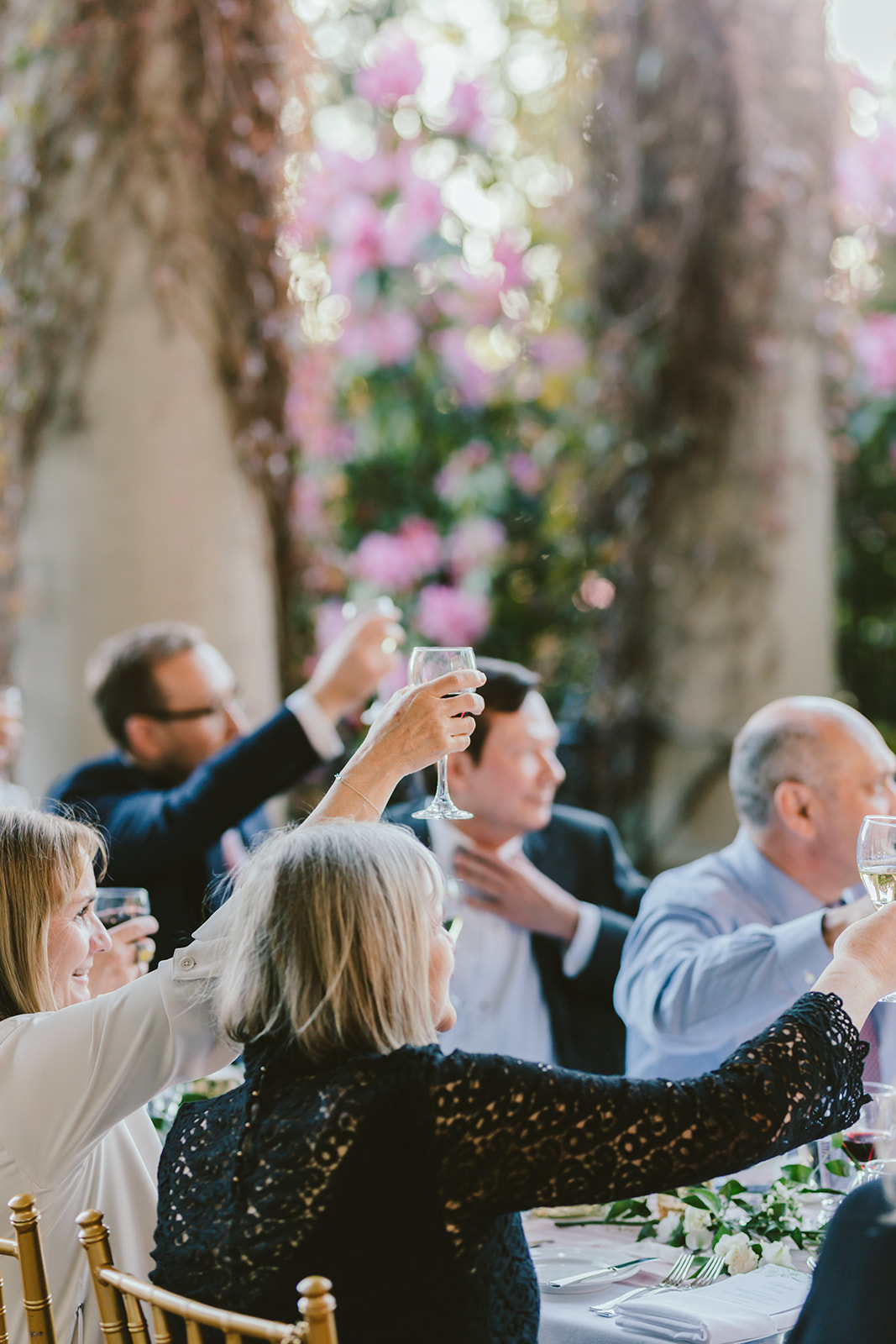 wedding guests raising their glasses during a wedding toast