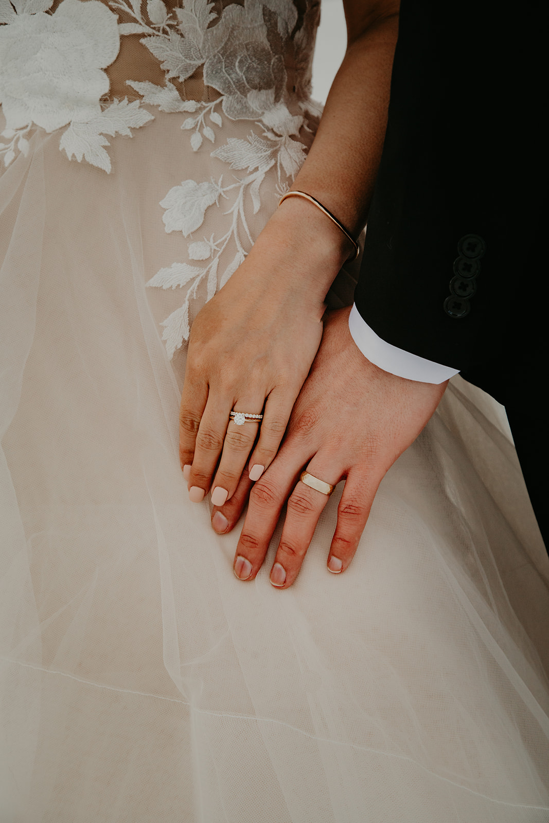 wedding rings with newlywed couple