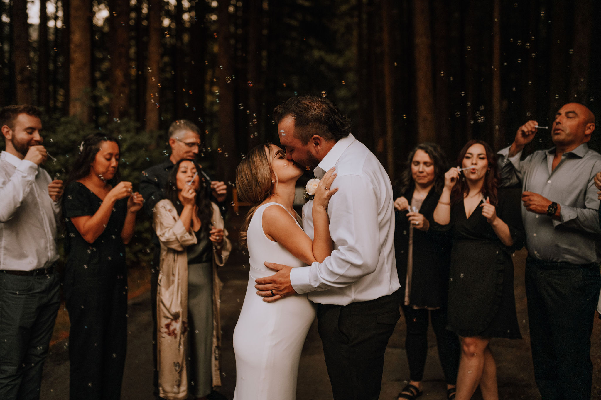 kissing at a wedding in forest elopement with young hip and married