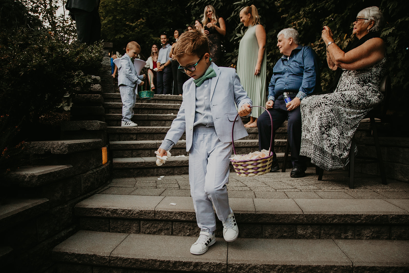 ring bearers and flower children coming down the aisle at a backyard wedding