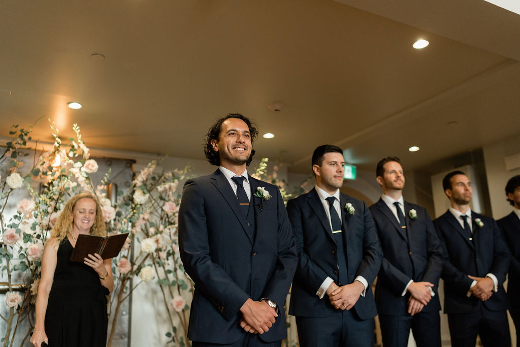 groom and groomsmen wait at the end of the aisle for the bride to enter during ceremony