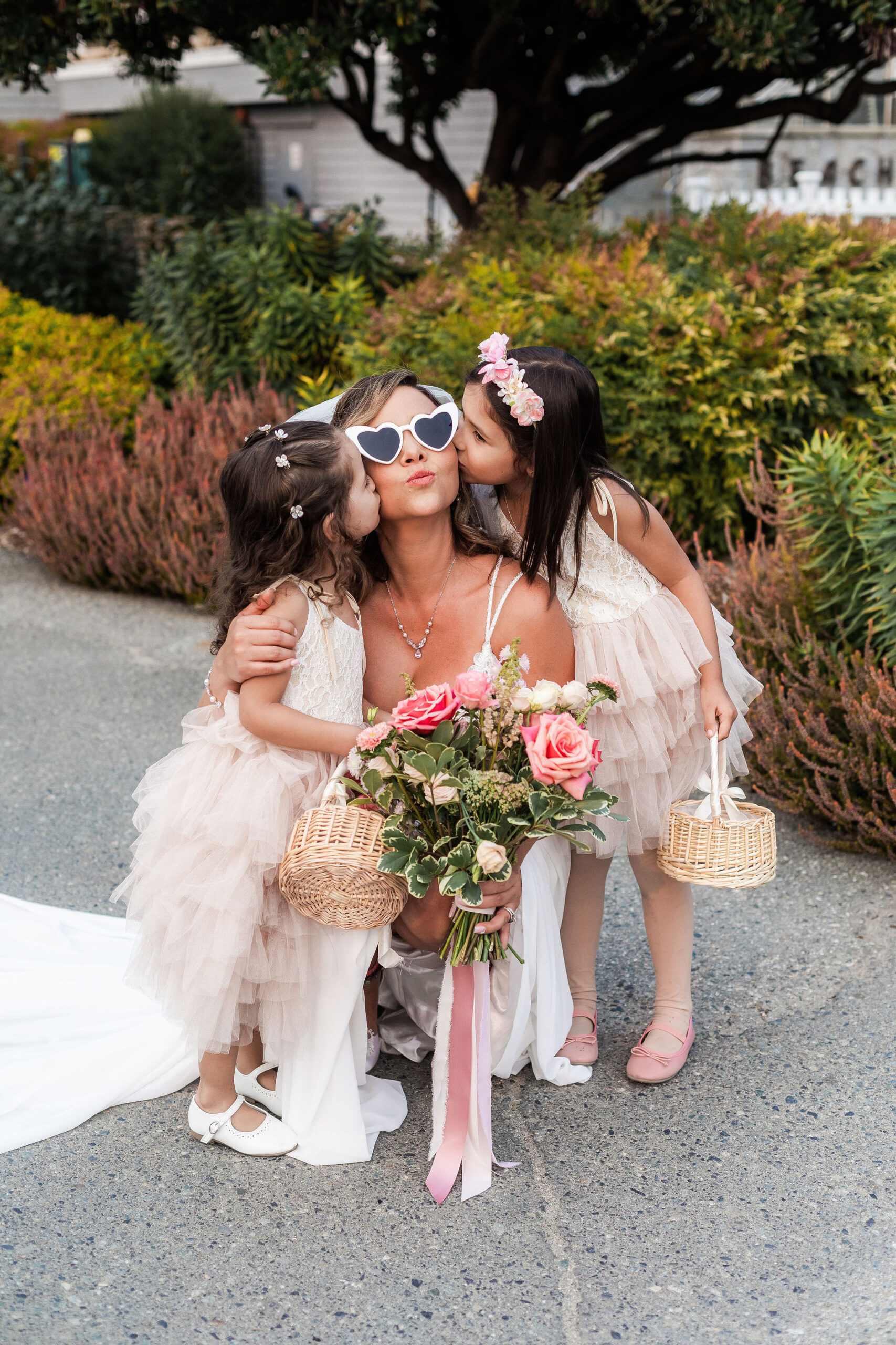flower girls kissing the bride before wedding ceremony
