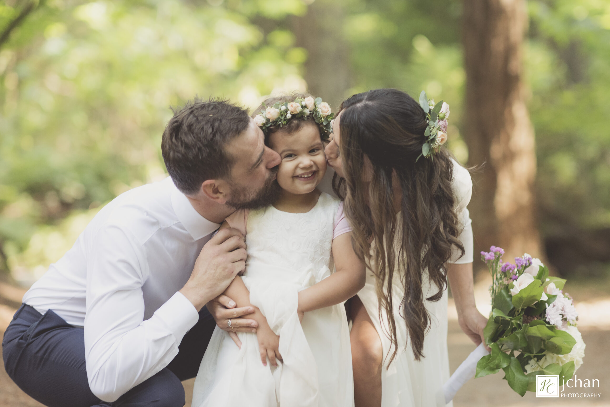 flower girl getting a kiss from the bride and groom at young hip and married wedding