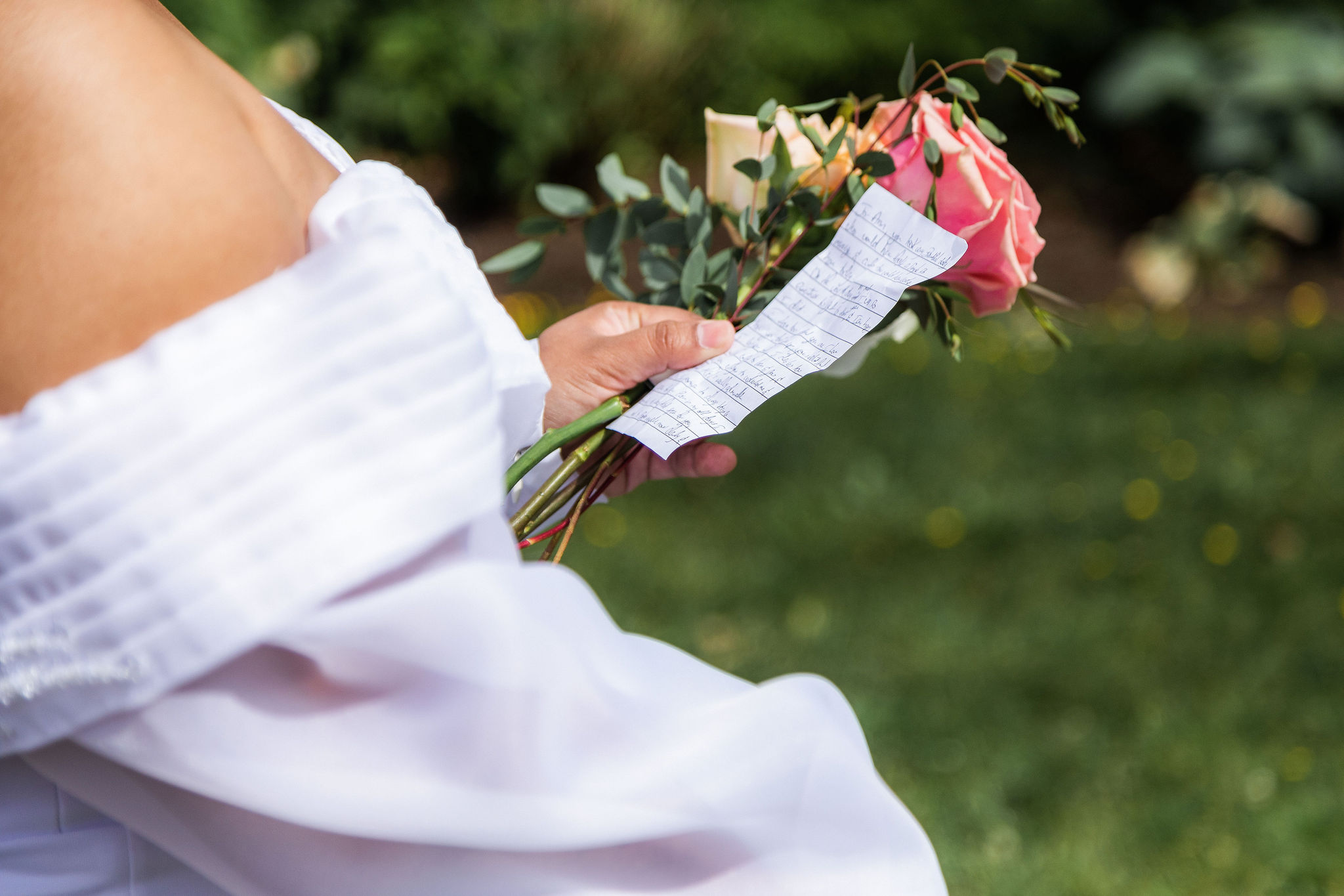 bride holding vows on paper during wedding ceremony