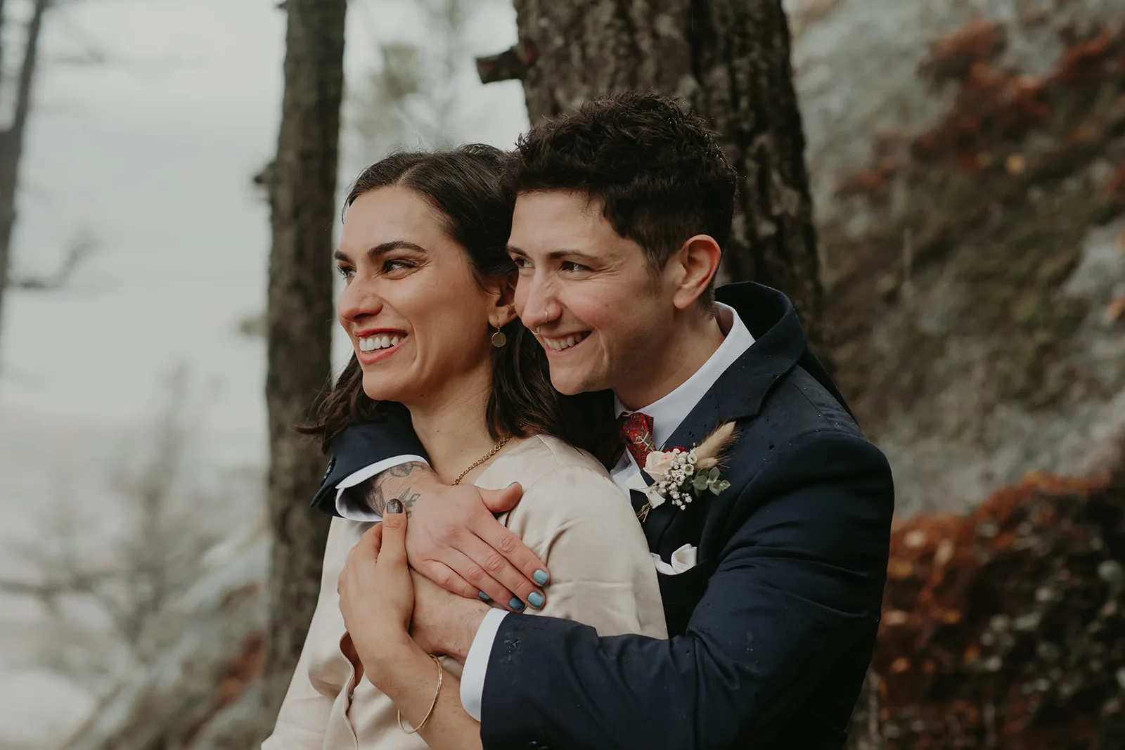 Couple embracing after their elopement ceremony, looking out at the view