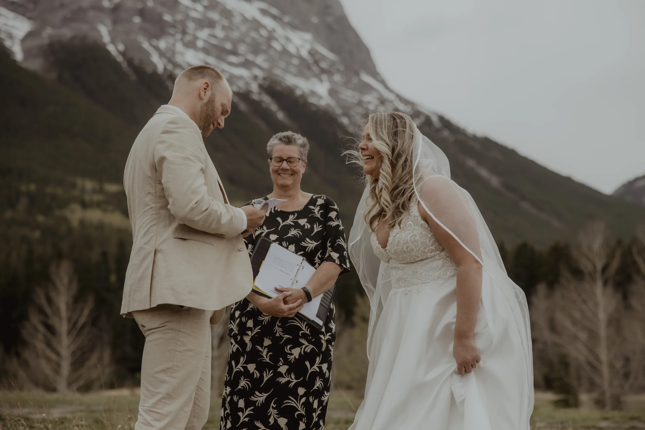 A man and a woman laugh during their outdoor wedding ceremony with a Young Hip & Married wedding officiant.